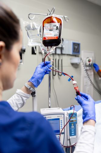 A nursing student prepare to set up an IV