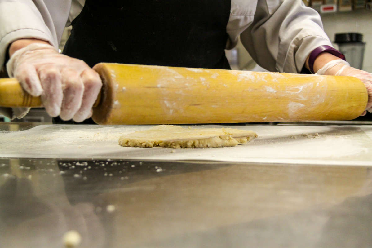 Rolling out the dough with a rolling pin.