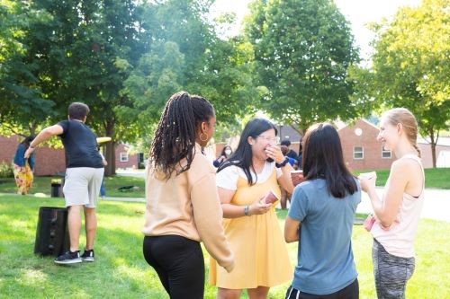 A group of multicultural female students laughing outside