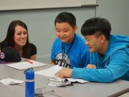 A teacher at the front of a classroom full of students