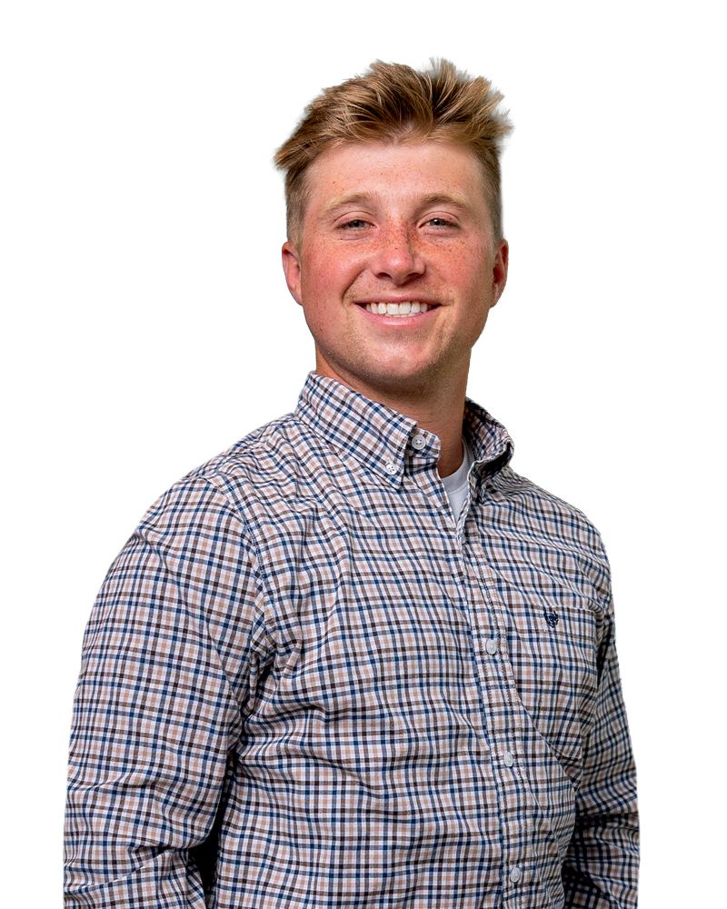 Smiling young man wearing a plaid button-up shirt, standing against a white background.